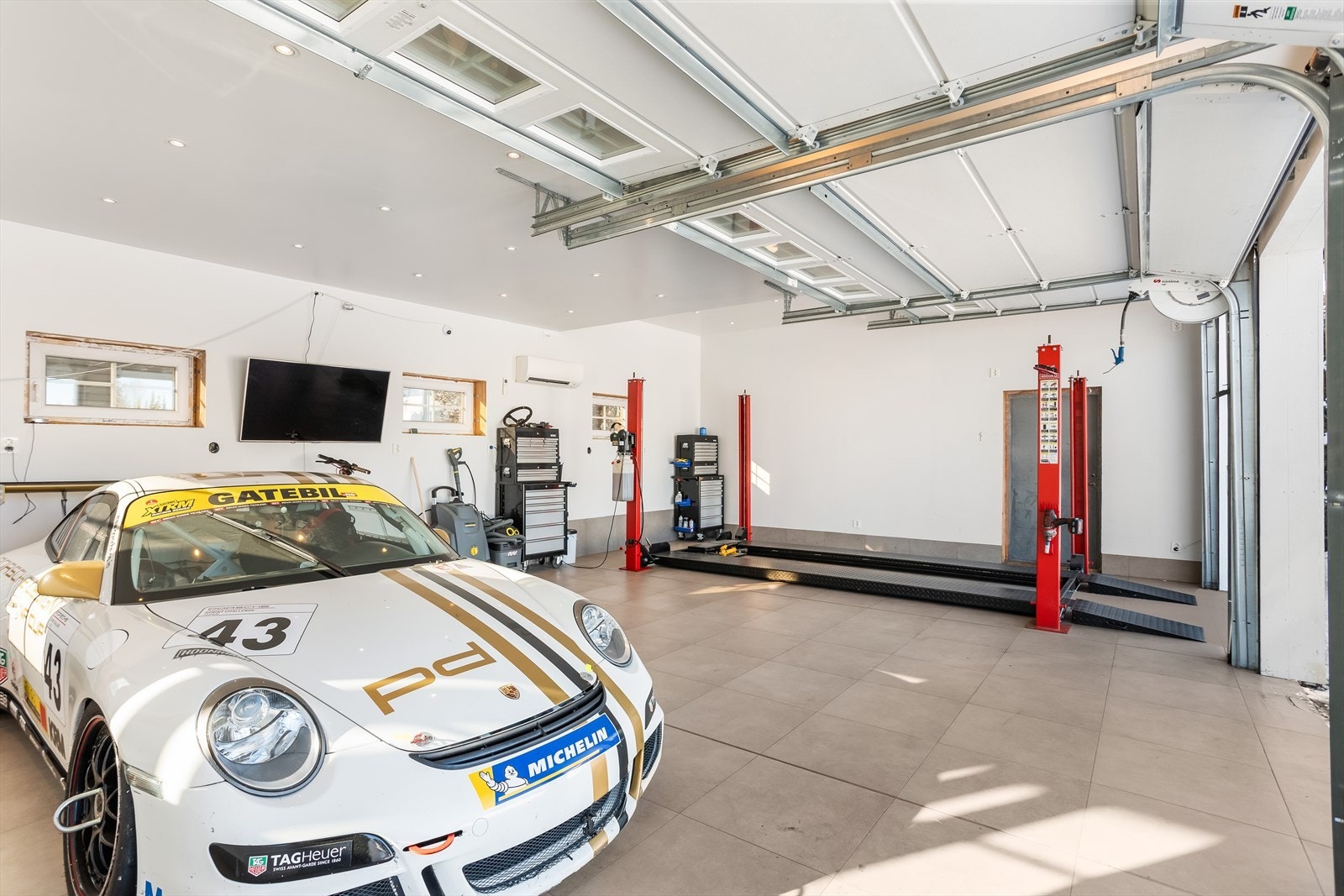 Den store garasjen har plass til tre biler og er utstyrt med tre leddporter. Galleribilde
