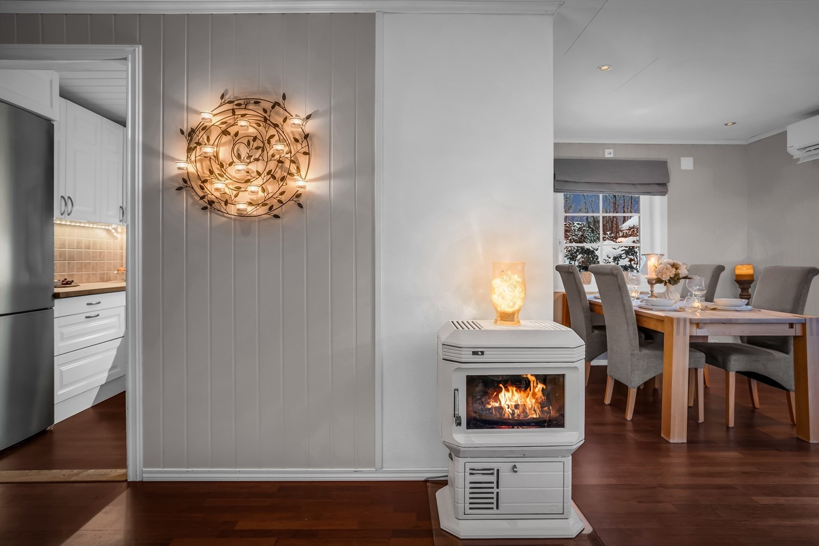 Ildstedet i stuen gir en lun atmosfære og supplerer boligens øvrige oppvarming. Galleribilde