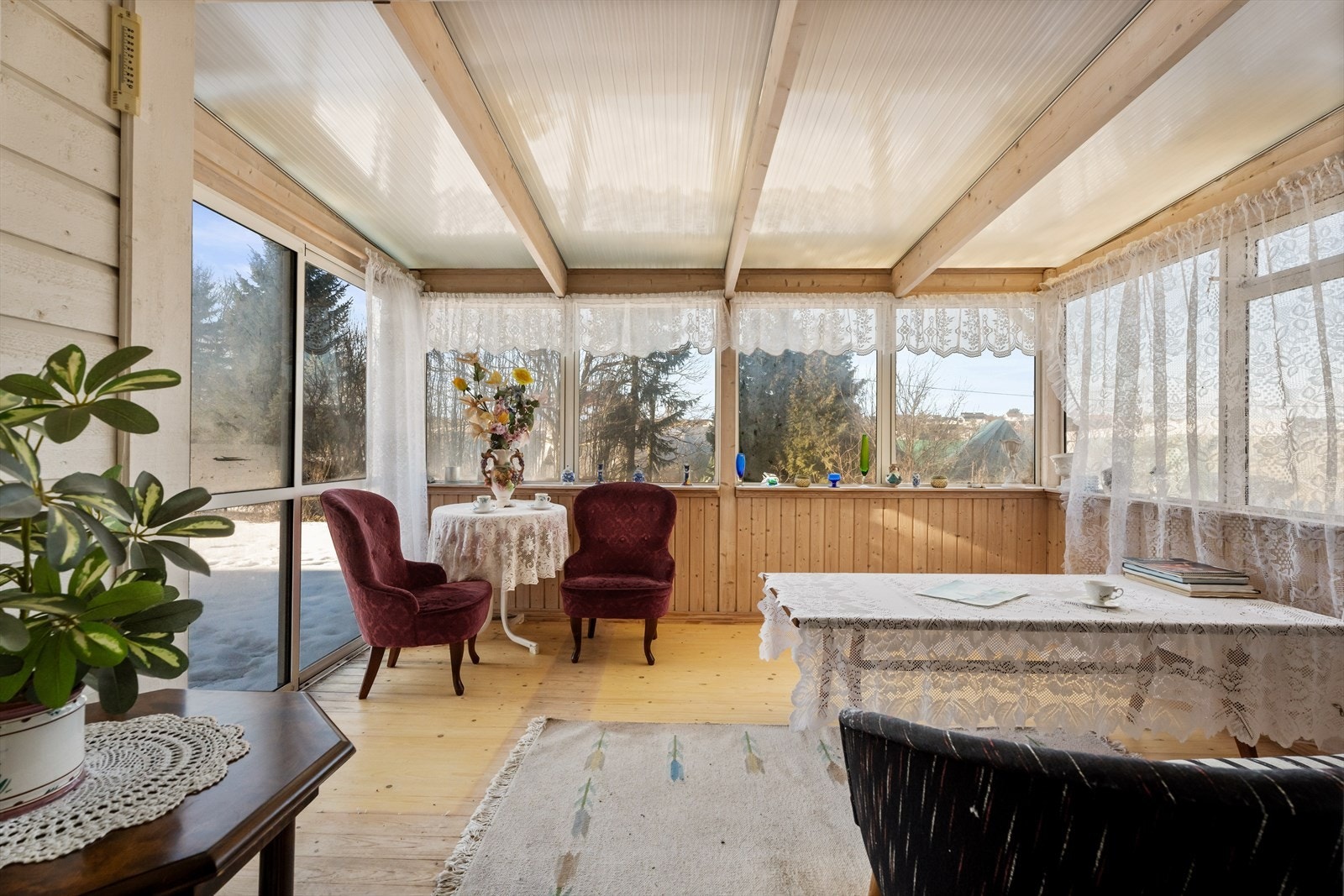 Et lyst og trivelig rom med panel på vegger og store vindusflater. Galleribilde