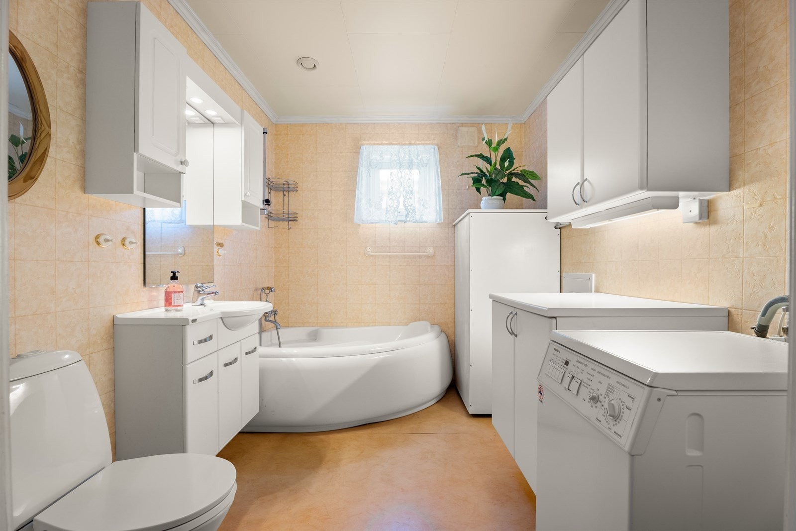 Badet er utstyrt med badekar, servantinnredning og opplegg for vaskemaskin. Galleribilde