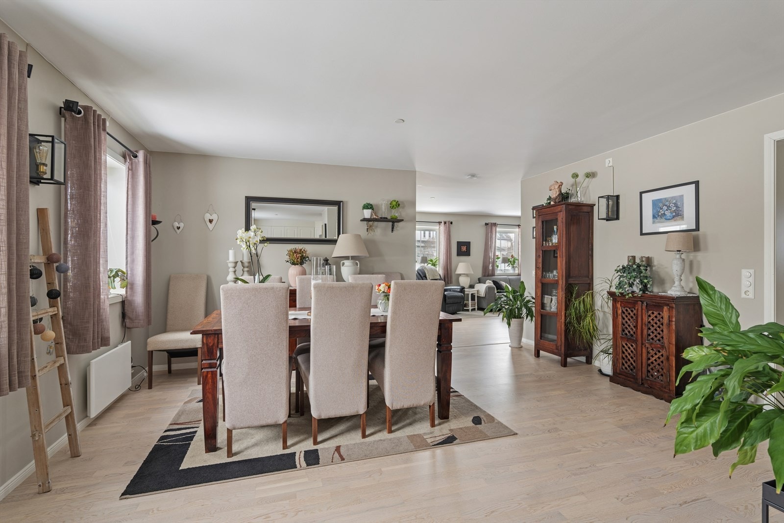 Like ved kjøkkenet finner man spisestuen som enkelt møbleres med stort spisebord Galleribilde