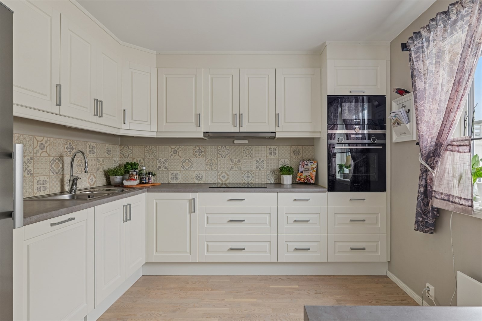 Kjøkkenet har godt med oppbevaringsplass og en praktisk løsning med flere arbeidssoner Galleribilde