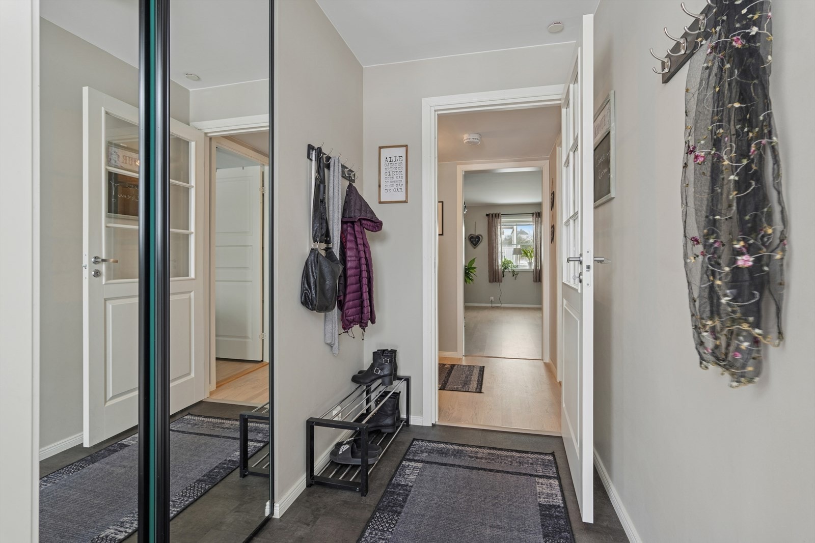 Man kommer inn i praktisk entrè med skyvedørsgarderobe med speildører Galleribilde