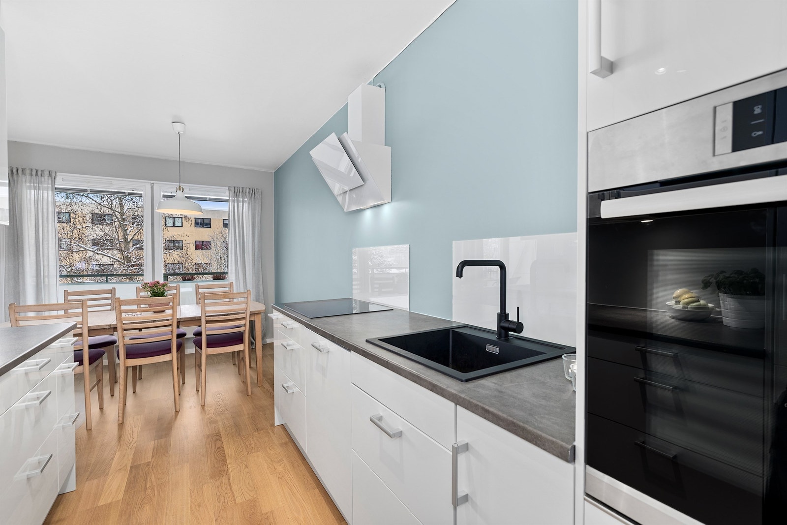 Kjøkkeninnredning fra 2016 med benkeplater av laminat. Praktisk glassplate er montert over benken for enkelt renhold. Galleribilde