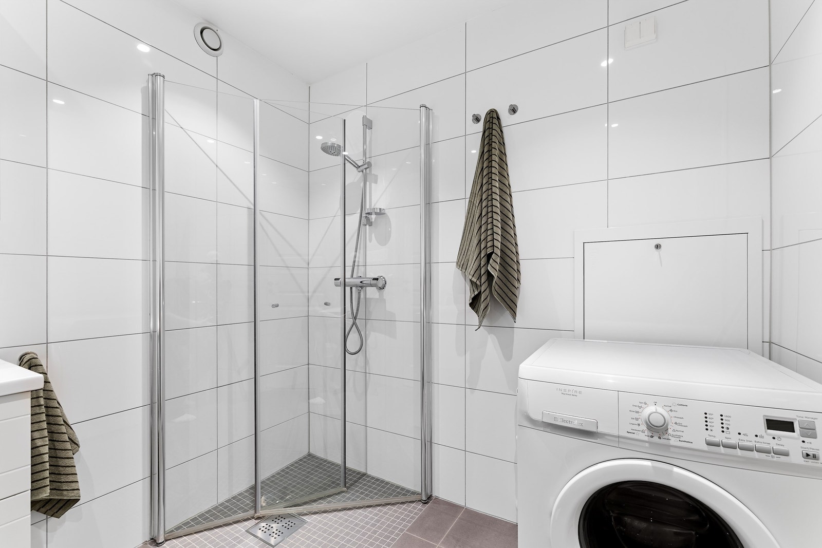 BDusjhjørne med innfellbare glassdører og opplegg for vaskemaskin. Galleribilde