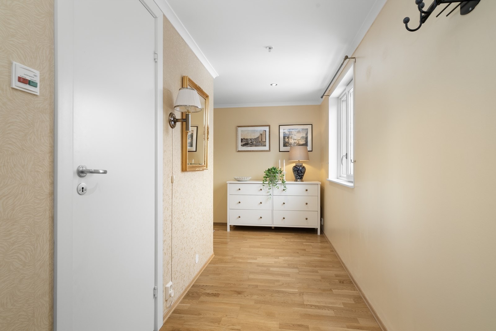 Lys og romslig hall med praktisk skyvedørsgarderobe og god plass til øvrig oppbevaringsmøblement ved behov. Galleribilde