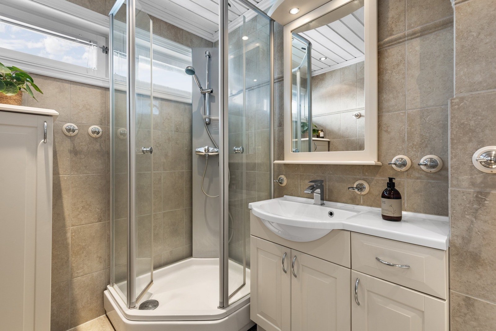 Boligen har to bad. Badet i hovedetasjen er delikat og flislagt med varmekabler i gulv og spotter i tak. Badet er utstyrt med servant på innredning, speil med lys, dusjløsning og toalett. Galleribilde