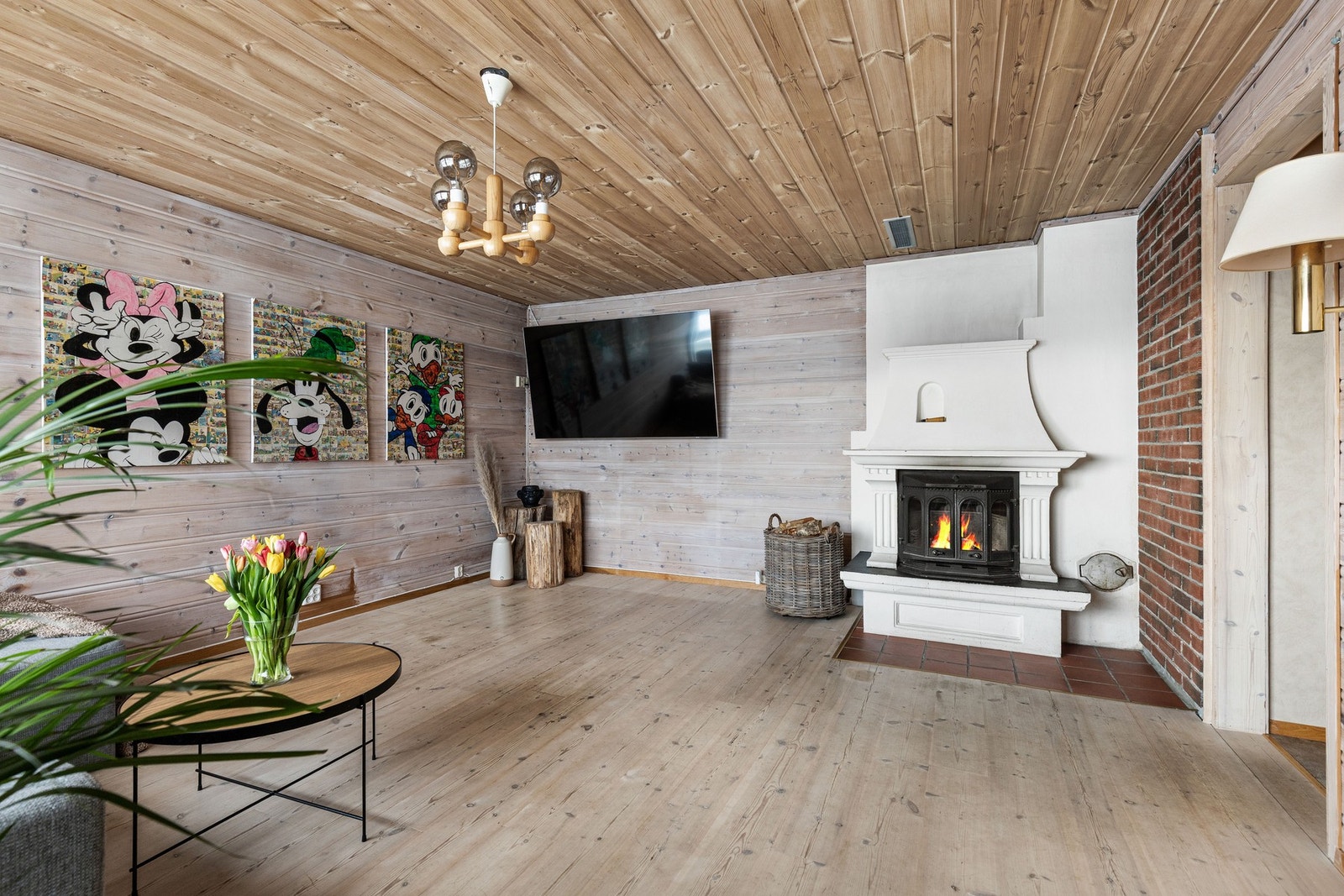 Underetasjen har en lun og romslig stue med peis. Her er det god plass til sittegrupper, og rommet egner seg perfekt som TV-stue. Galleribilde