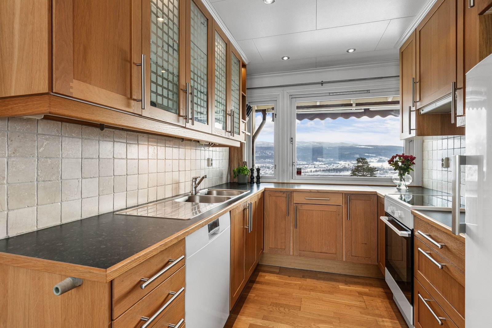 Innredningen har profilerte fronter og laminat benkeplate, med fliser på vegg over benk. Galleribilde