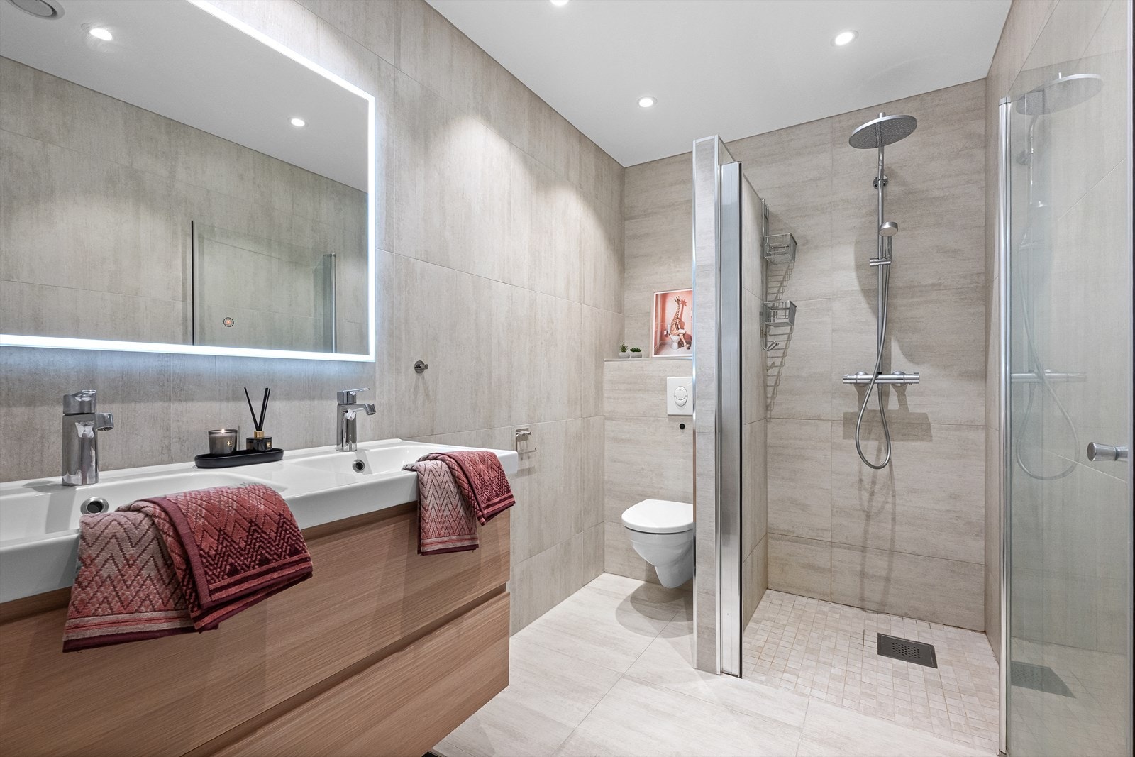 Pent helfliset bad utført med dobbeltservant, dusjnisje og vegghengt toalett. Galleribilde