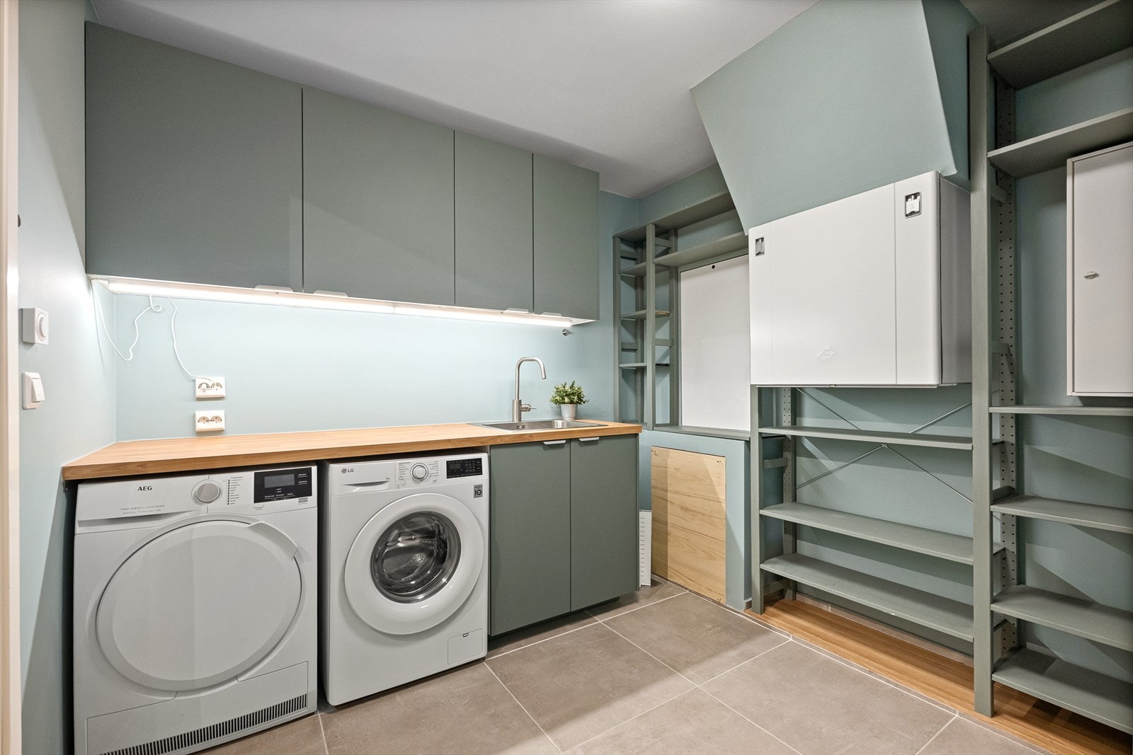 Vaskerommet er innredet med fliser på gulv og god benk/skap løsning. Galleribilde