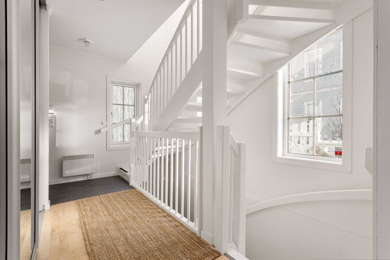 Innvendig møtes du av en lys entré med fliser på gulv som går over til parkett, og malte overflater. Galleribilde