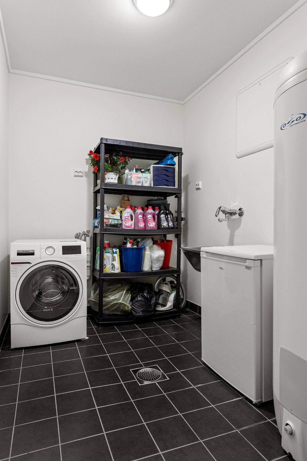 Boligens vaskerom er innredet med utslagsvask og har opplegg for vaskemaskin. Galleribilde