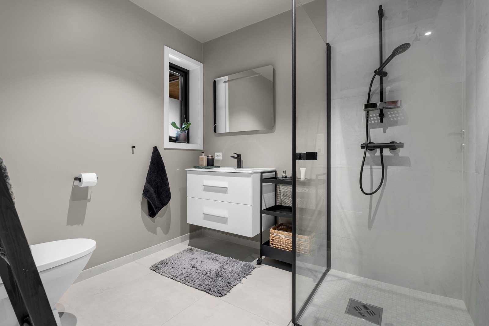 Bad 1 er innredet med dusjhjørne, toalett og servant med underskuffer Galleribilde