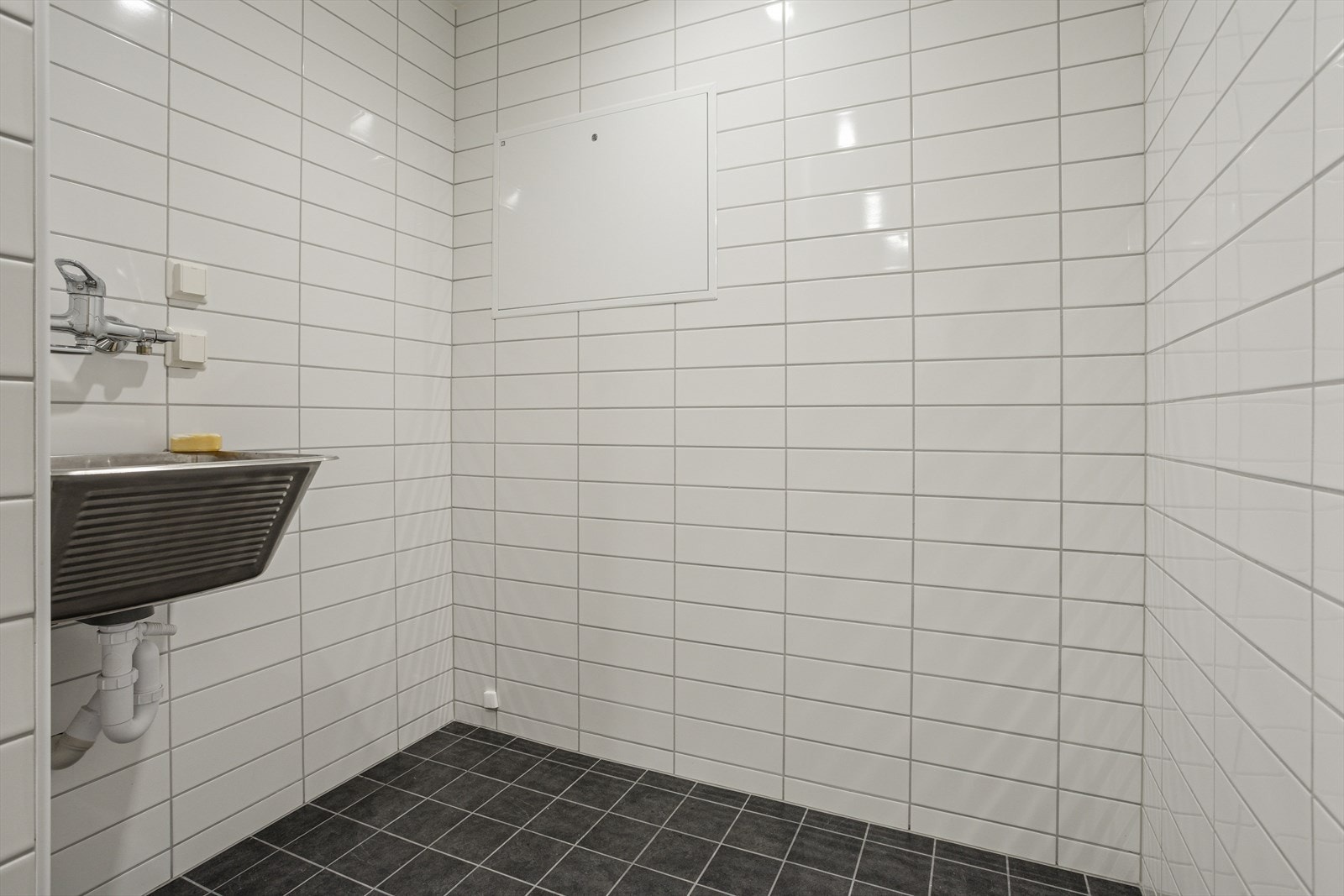 Bad/vaskerom med utslagsvask og opplegg for vaskermaskin Galleribilde