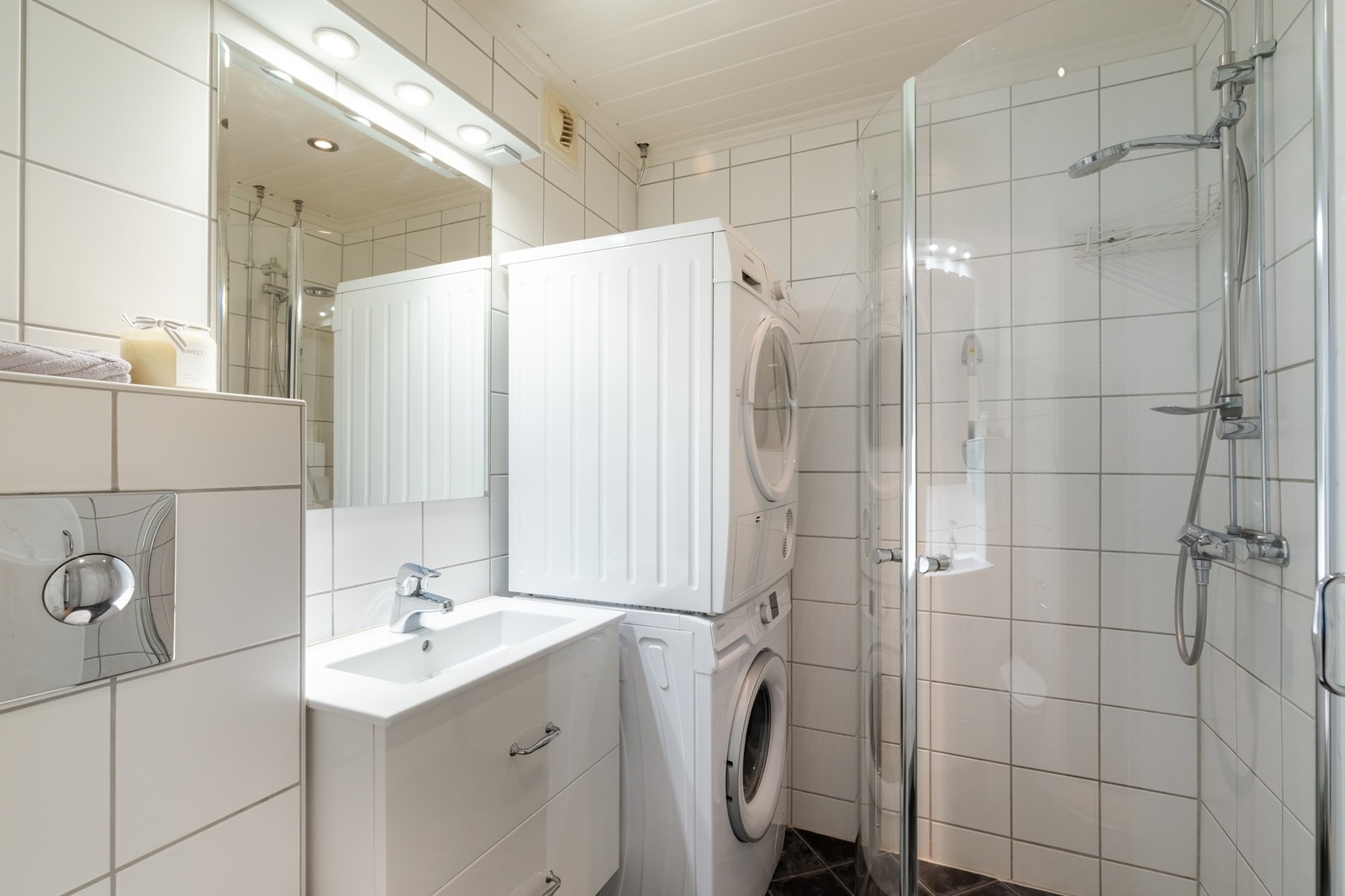 På badet er det innredning med to skuffer og ovenpåliggende servant, samt speil med lys over. Det er i tillegg vegghengt toalett og dusj med innfellbare dusjdører. Galleribilde