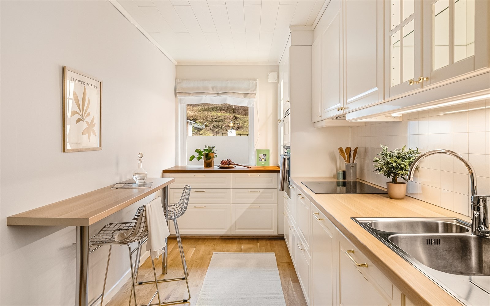 Kjøkkenet har takhøy innredning med belyste skap med glassfronter. Det er også belysning under overskap. Galleribilde