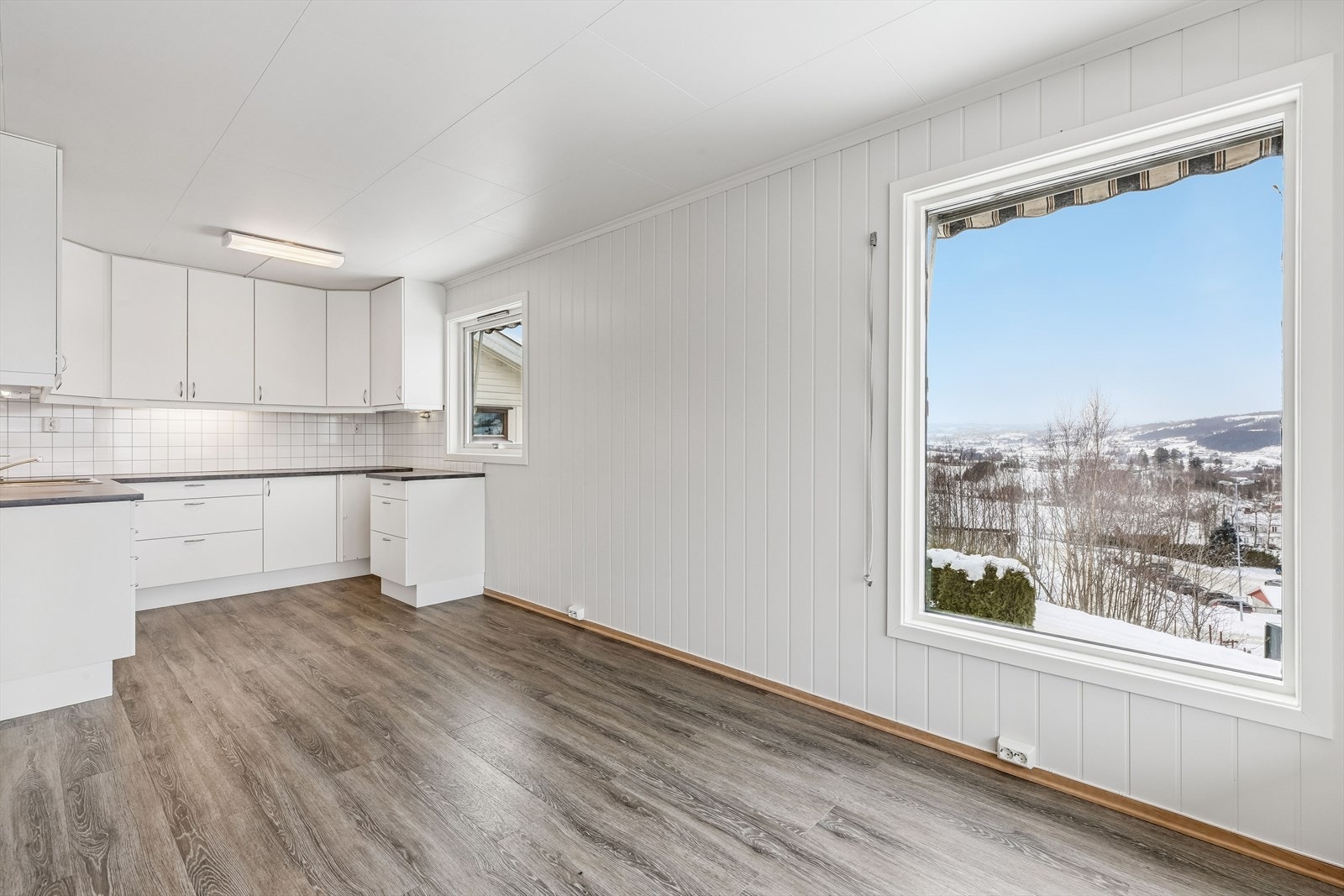 De gjennomgående overflatene med takessplater og laminatgulv skaper en helhetlig følelse. Galleribilde