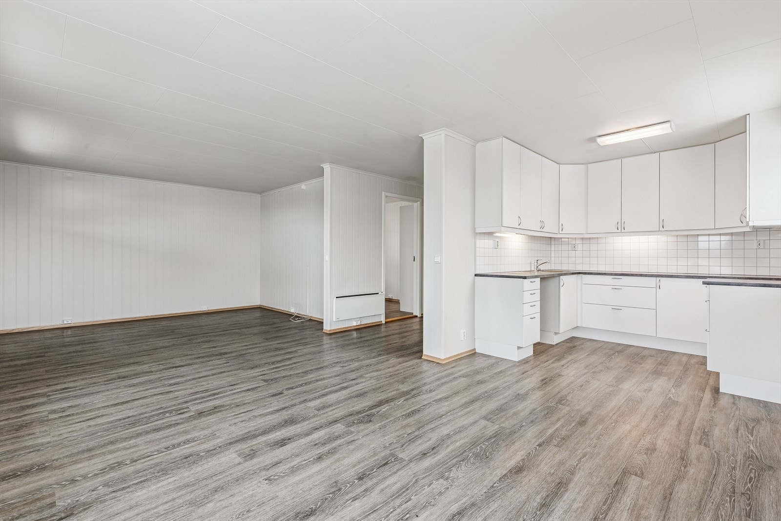 Stue og kjøkken i åpen løsning gir en sosial og romslig atmosfære. Galleribilde