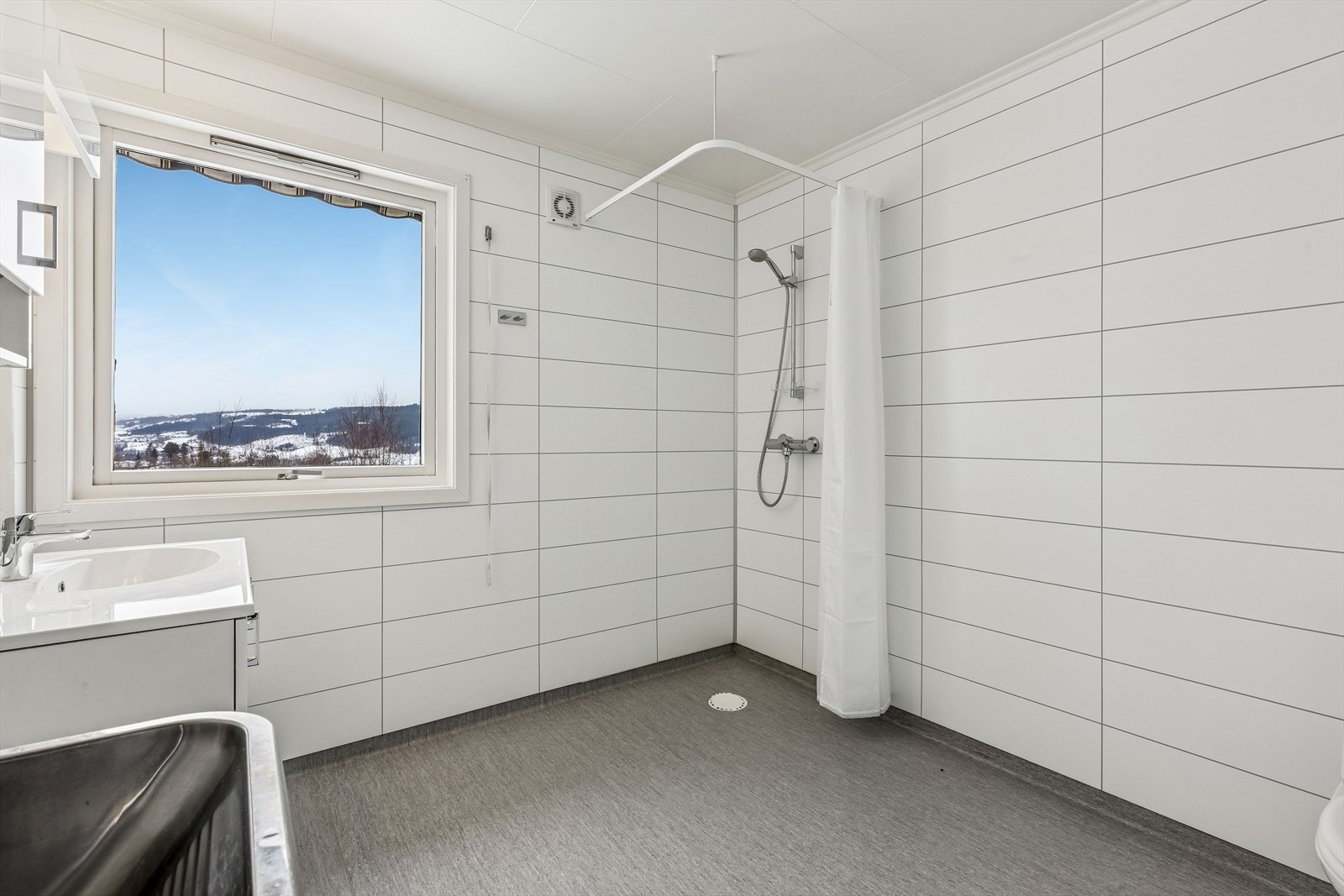 Rommet har en funksjonell dusjnisje og behagelige varmekabler i gulvet. Galleribilde