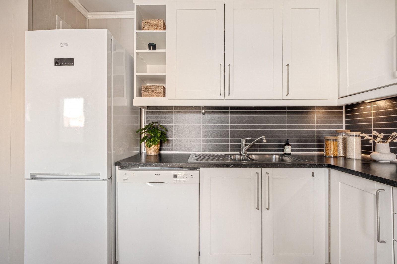 Kjøkkenet har innredning med glatte fronter og benkeplate av laminat. Galleribilde