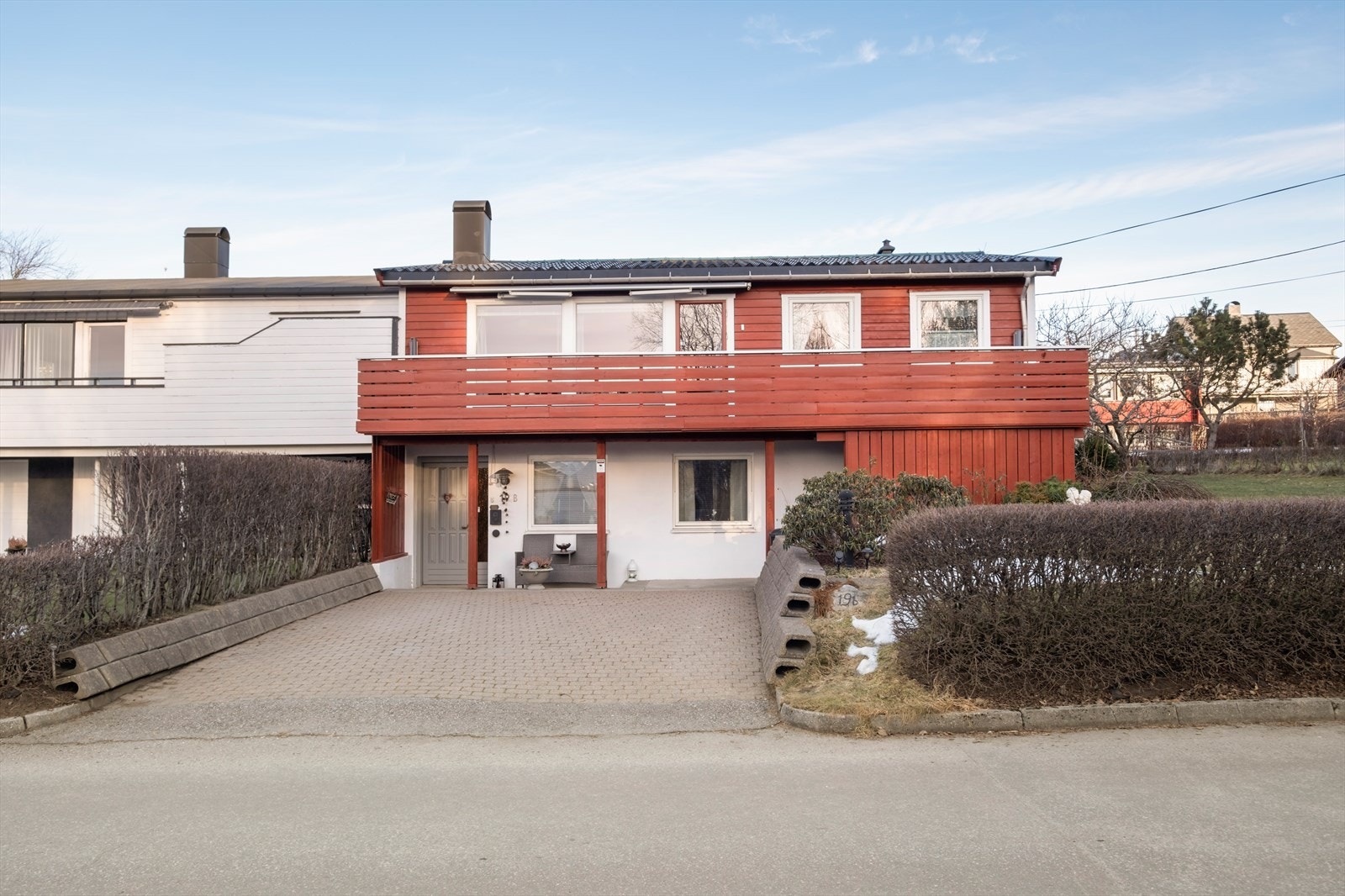 Inngangspartiet har belegningsstein og en malt hovedytterdør med sidevindusfelt. Galleribilde