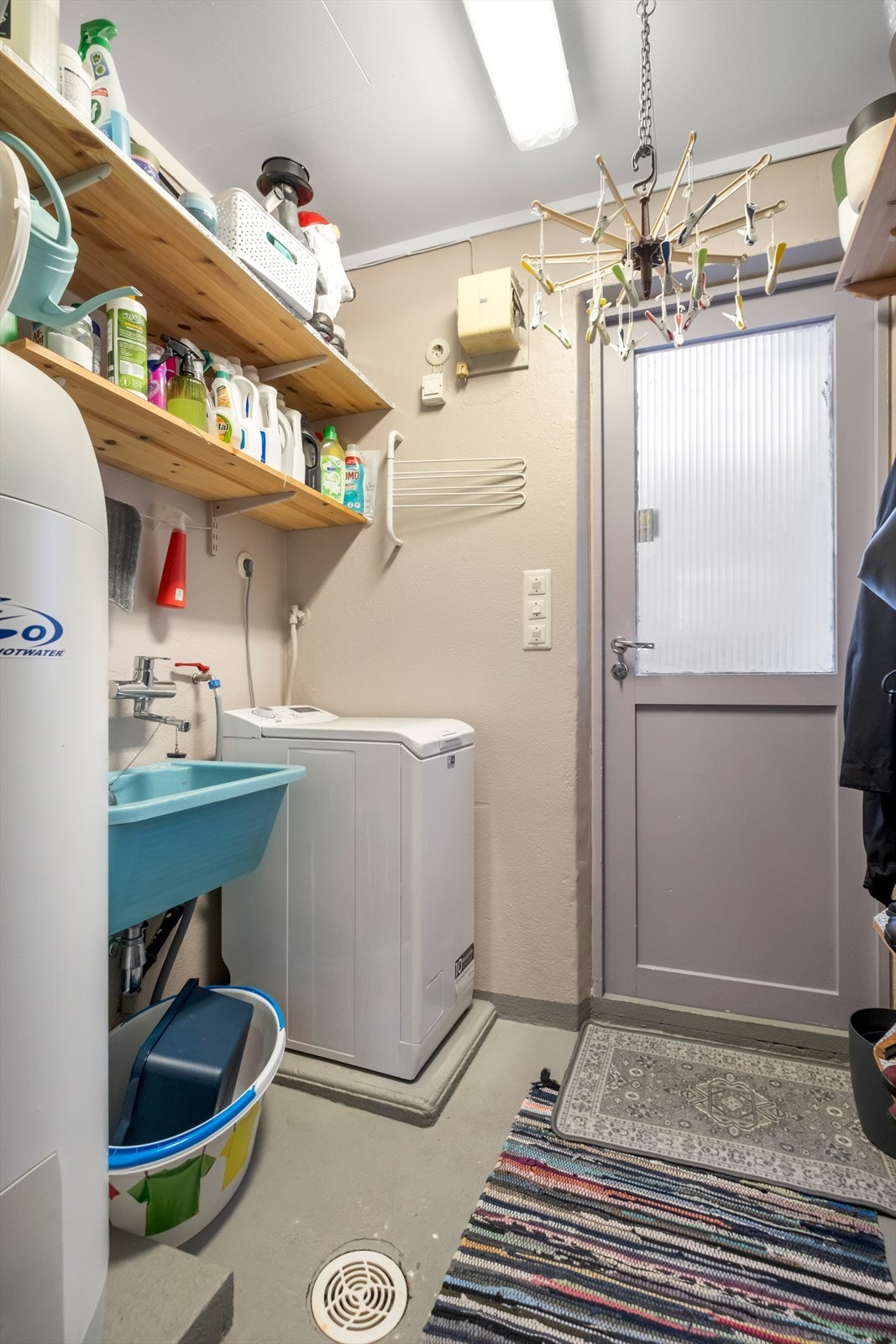 Vaskerommet har betonggulv og malte vegger, med opplegg for vaskemaskin. Galleribilde