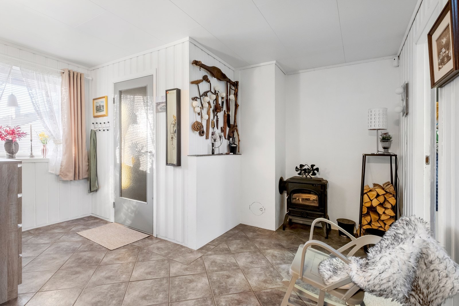 Vedovn bidrar med jevn varme i gangen, og flislagt gulv gir en robust overflate. Galleribilde