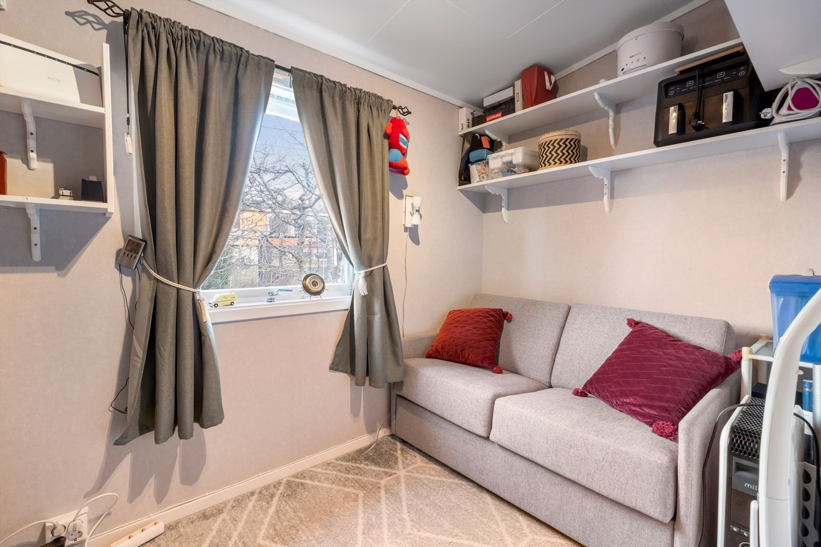 Sofa og vegghyller gir fleksibel oppbevaring i rom med tapetserte vegger. Galleribilde