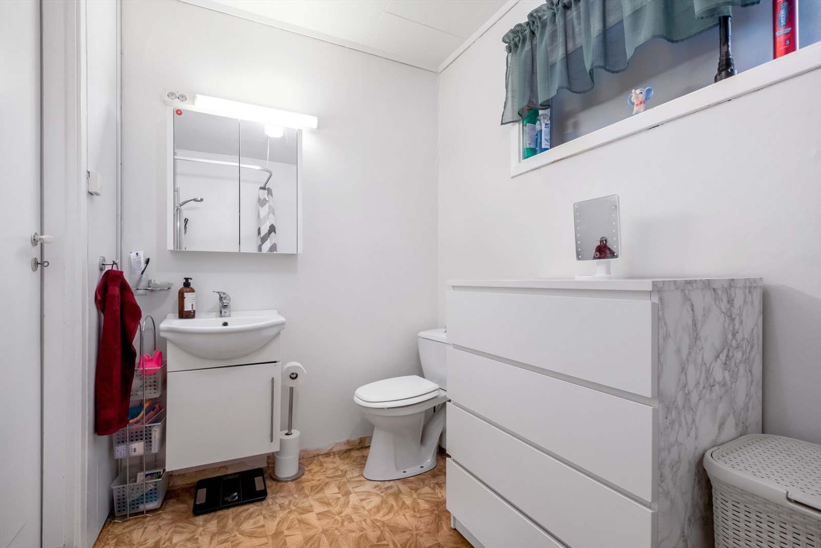 Gulvbelegg og vegger med delvis våtromsplater og tapet. I taket er det himlingsplater. Galleribilde