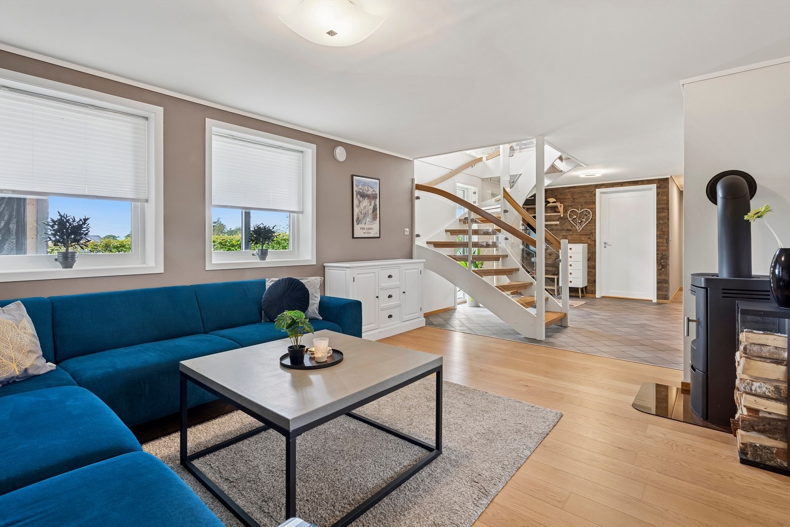 Stuen i underetasjen er stor og funksjonell, med naturlig lysinnslipp og en peisovn som skaper et varmt og innbydende miljø. Galleribilde