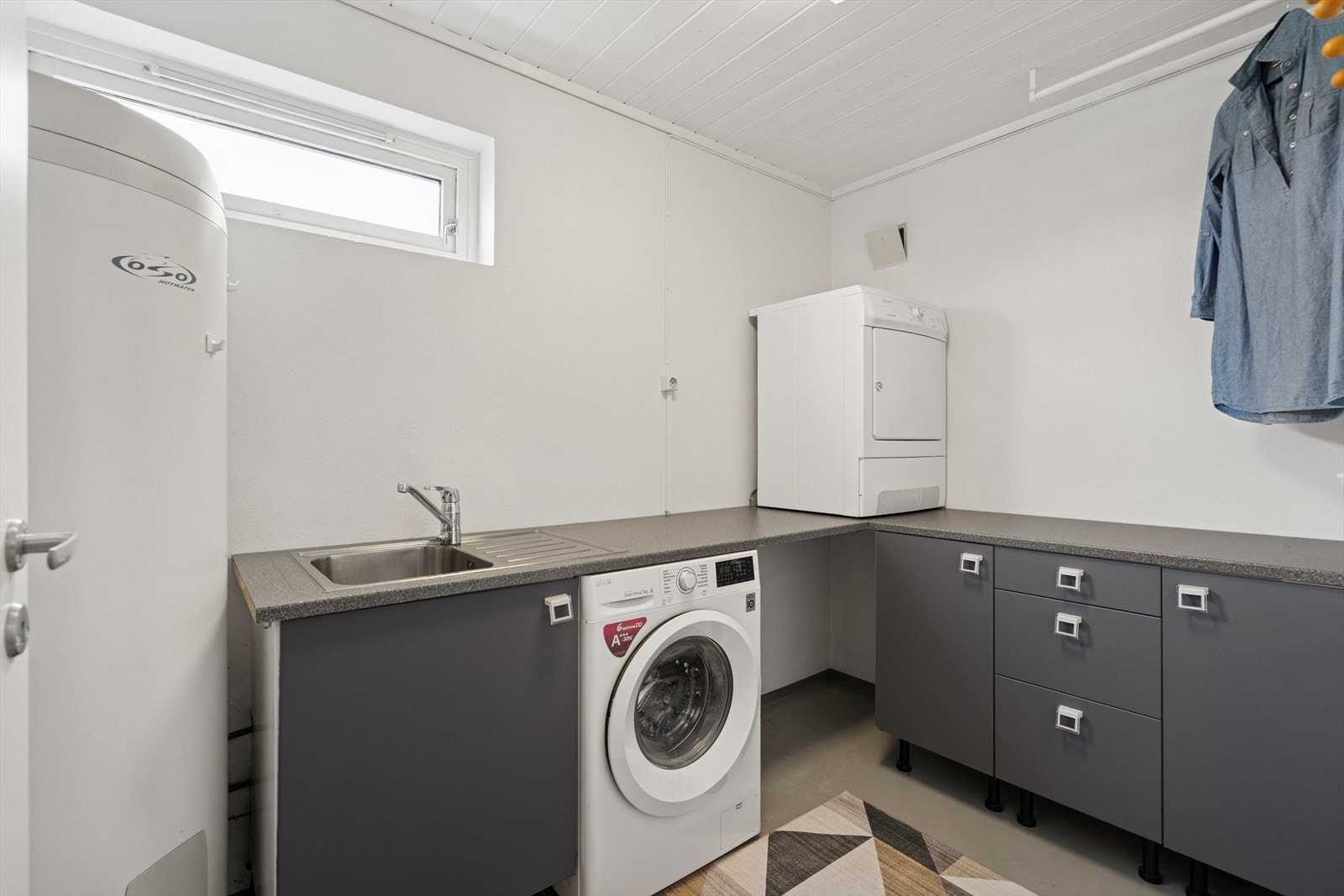 Vaskerommet er praktisk innredet med god skapplass, benk og opplegg for både vaskemaskin og tørketrommel. Galleribilde