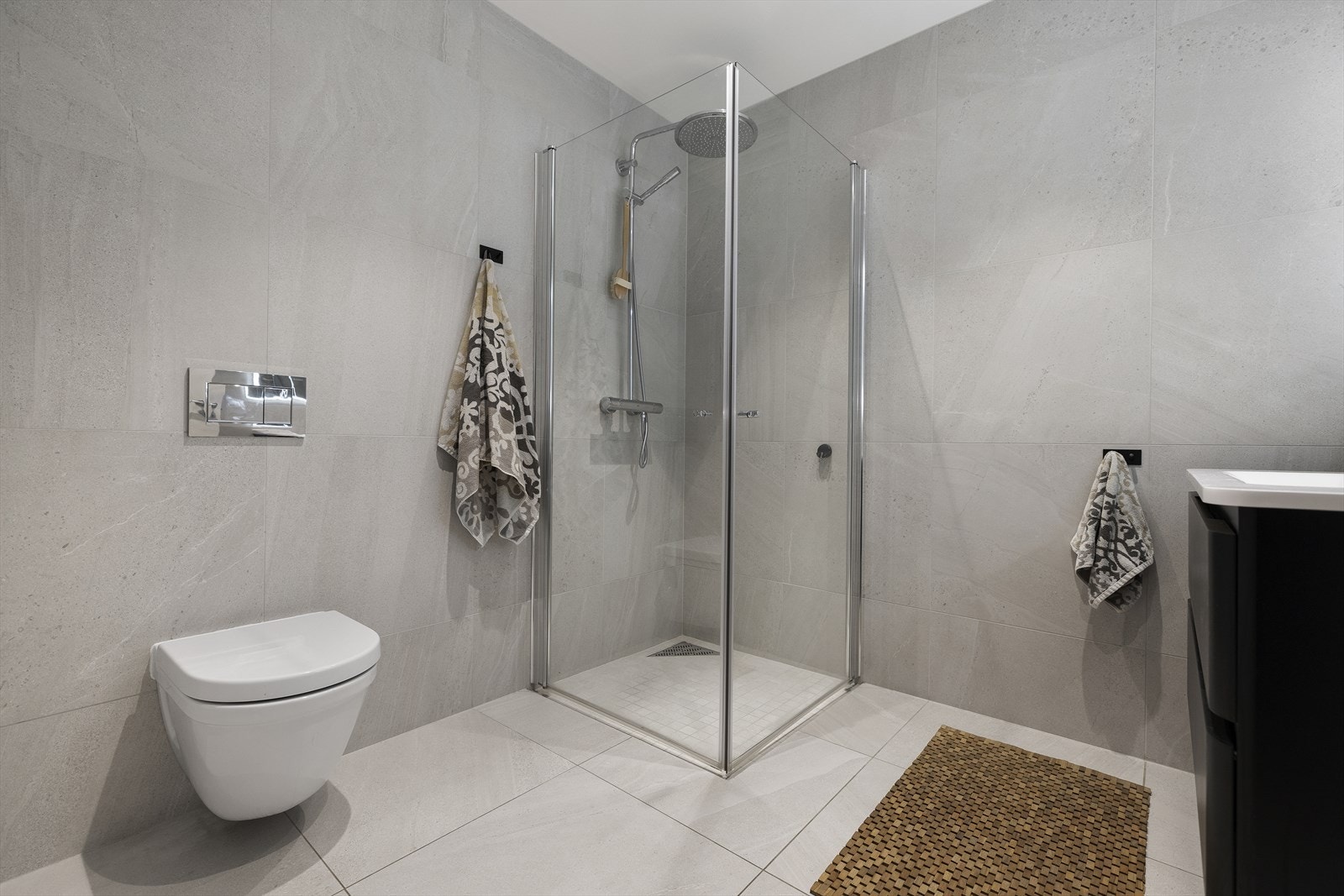 Dusjhjørne med glassvegg og veggmontert toalett Galleribilde