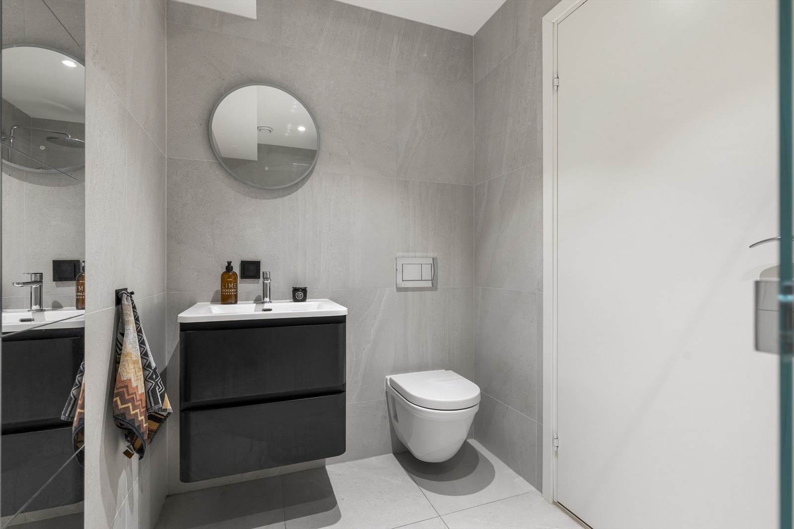 Pent bad innredet med servantskap med blandebatteri, og veggmontert toalett Galleribilde