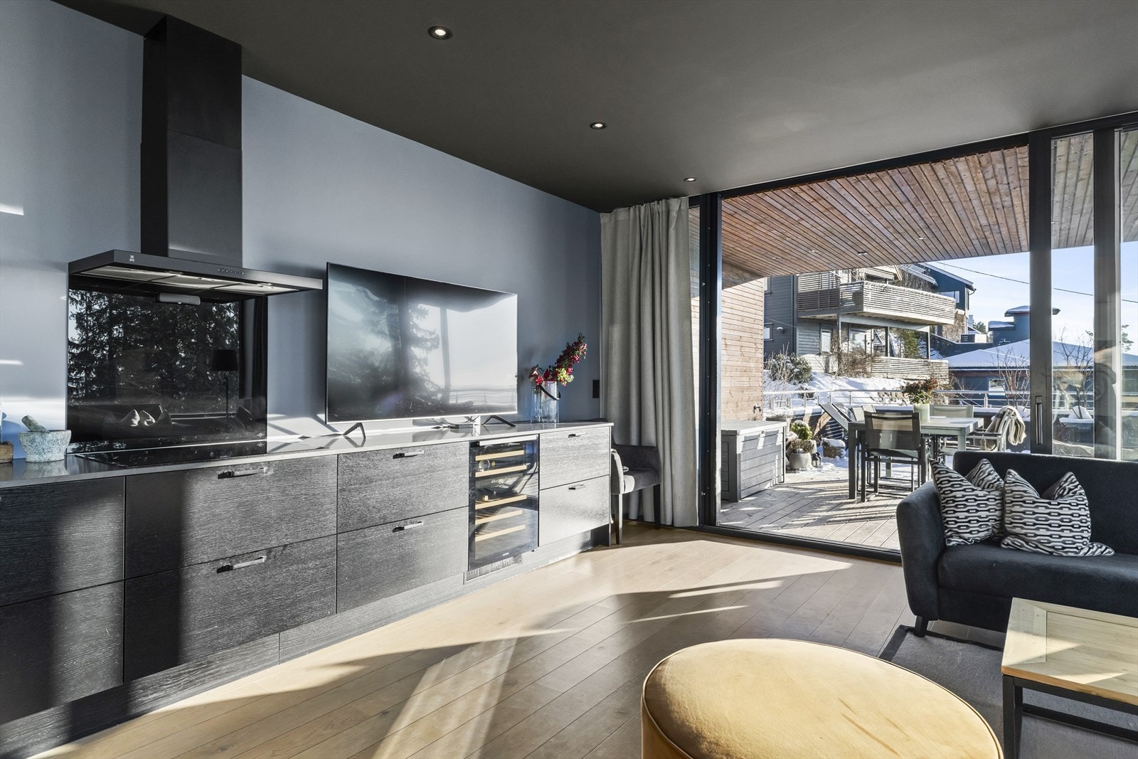 Integrerte hvitevarer gir et ryddig og helhetlig preg, og kjøkkenet er utstyrt med kvalitetsprodukter fra AEG, inkludert kaffemaskin, tallerkenvarmer, stekeovn, platetopp, kjøl/frys og oppvaskmaskin. I tillegg er det et integrert vinskap fra Noorcool Galleribilde