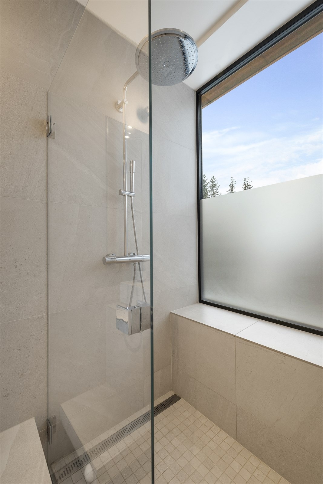 Dusjen har et stort vindu som slipper inn rikelig med dagslys og gir en helt spesiell følelse - her kan du usjenert stå å dusje med utsikten og naturen tett på Galleribilde