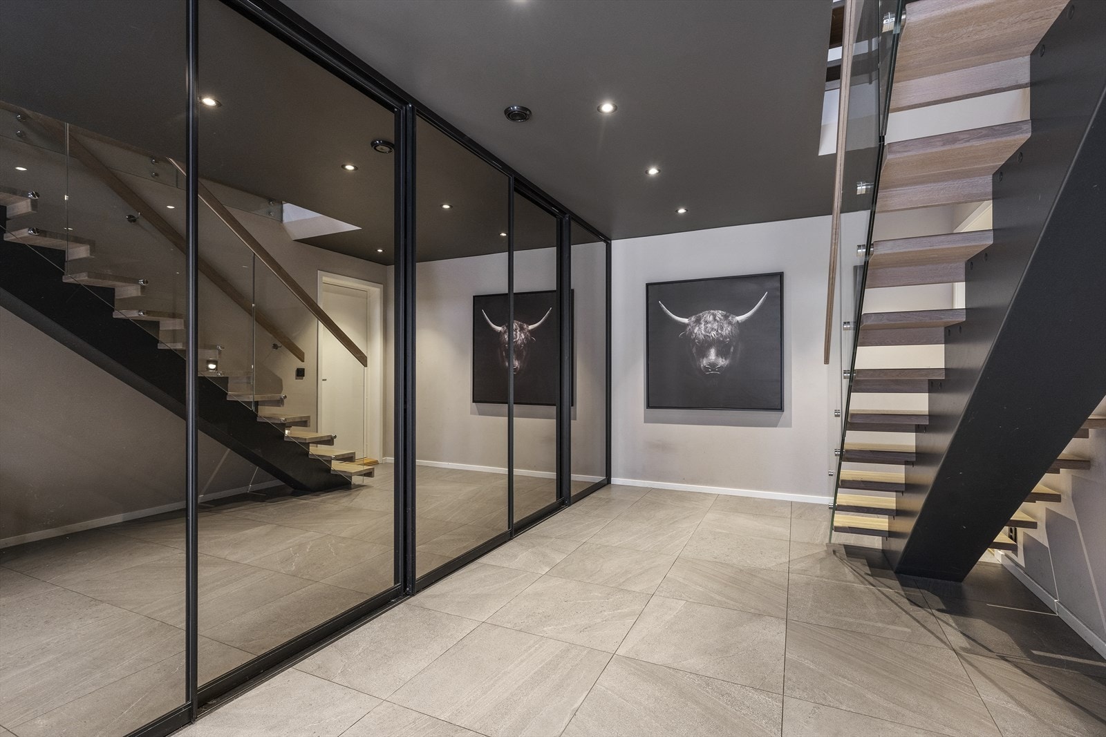 Stilig flislagt inngangsparti. I bunn av trappen er det dør inn fra garasjen Galleribilde