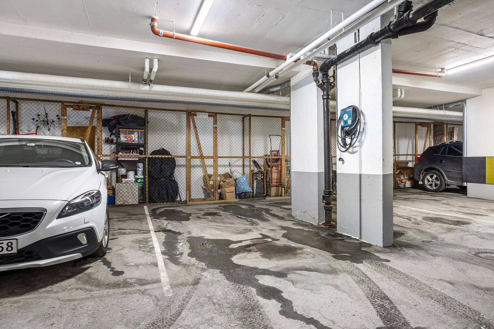 Garasjeplass med elbil lader og sportsbod. Galleribilde