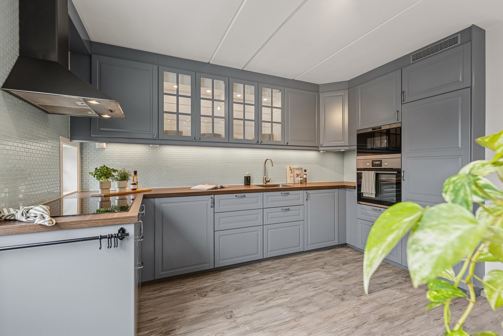 Kjøkkenet har en pen Ikea-innredning fra 2017, med malte profilerte fronter, noen overskap med glassfronter og en laminert benkeplate som gir både funksjon og et tidløst uttrykk. Galleribilde