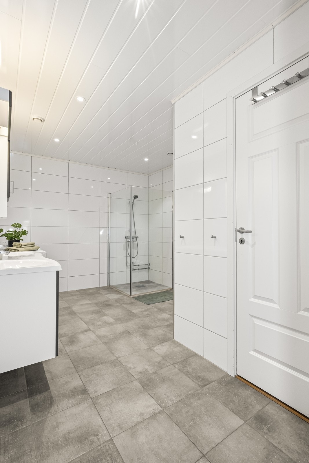 Romslig bad med innredning som inkluderer to servanter og opplegg for vaskemaskin. Galleribilde