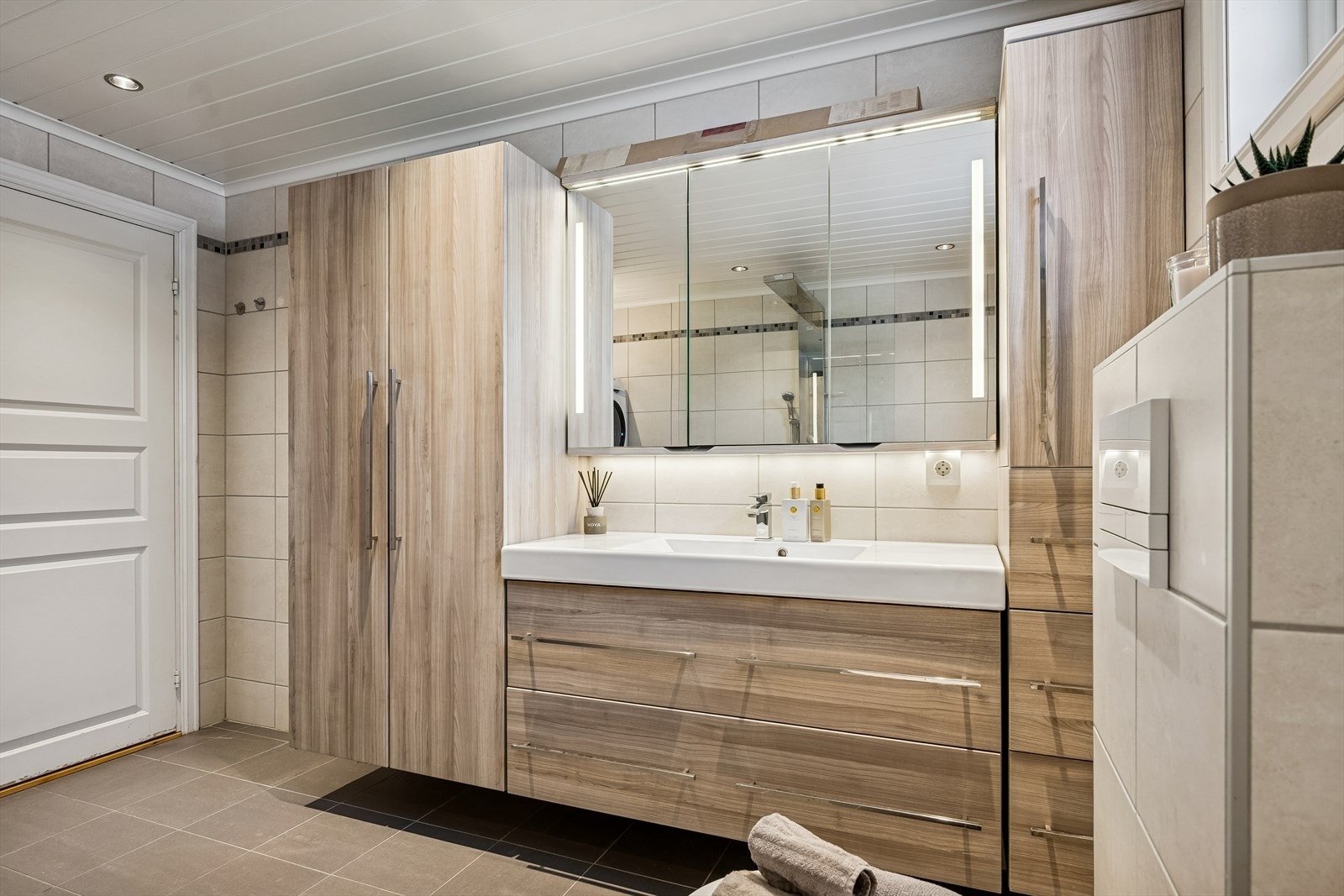 Innredningen har slette fronter, heldekkende servant, ett-greps blandebatteri og speilskap med lys, som gir god funksjonalitet. Galleribilde