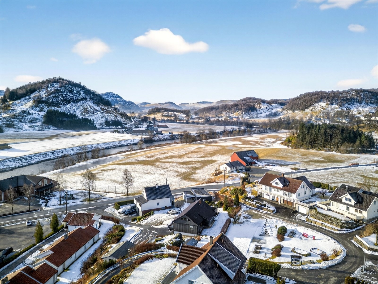 Huset er i naturlige omgivelser med plen og uteplass. Galleribilde