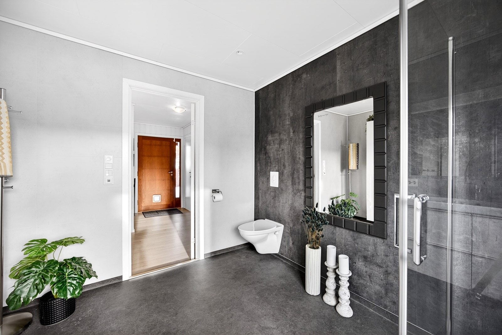 Badet er utstyrt med servant, dusj og toalett i en stilren utførelse. Galleribilde