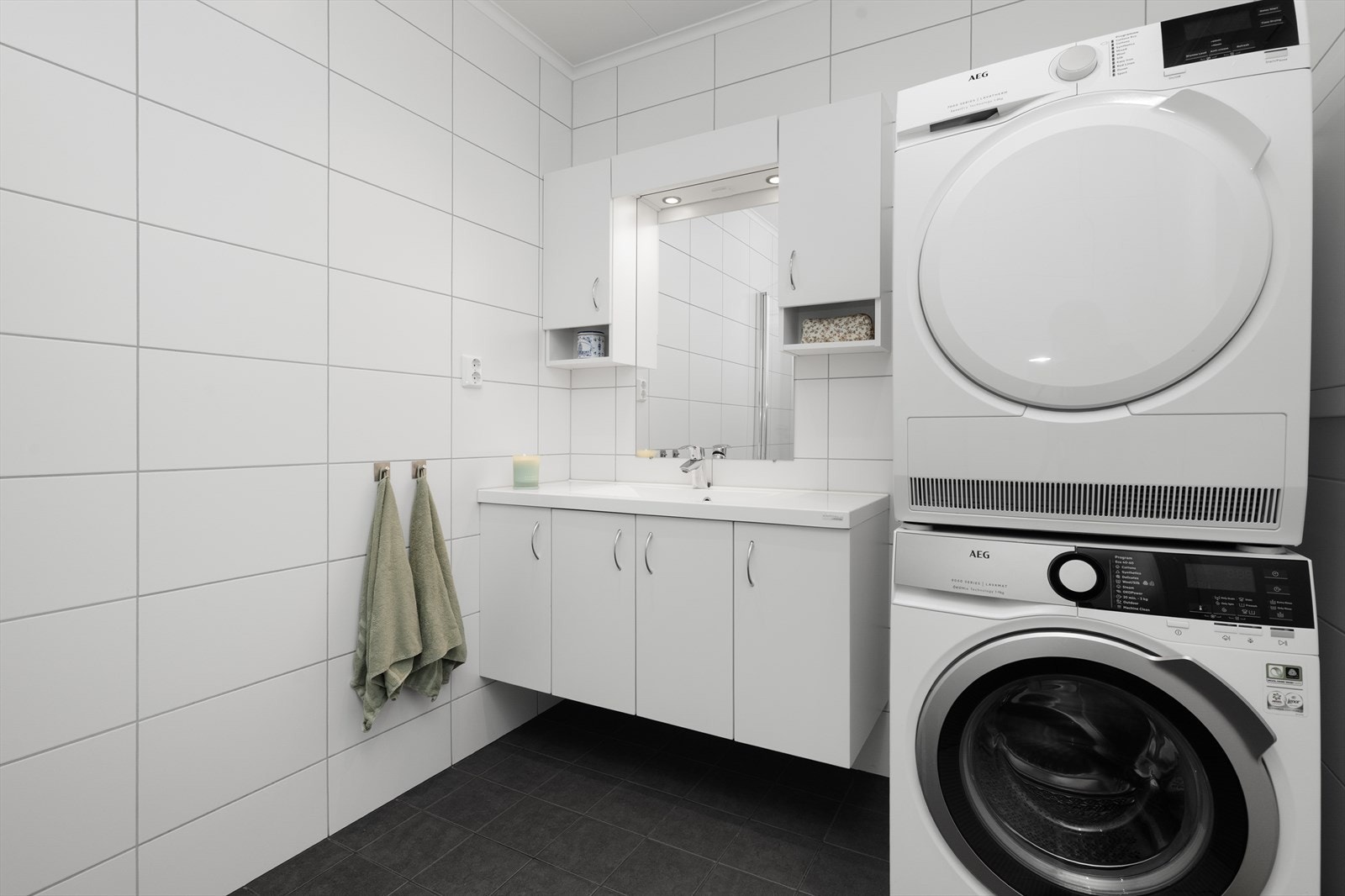 Pen servantinnredning med skap og heldekkende servant. Det er også etablert opplegg for vaskemaskin og tørketrommel. Galleribilde