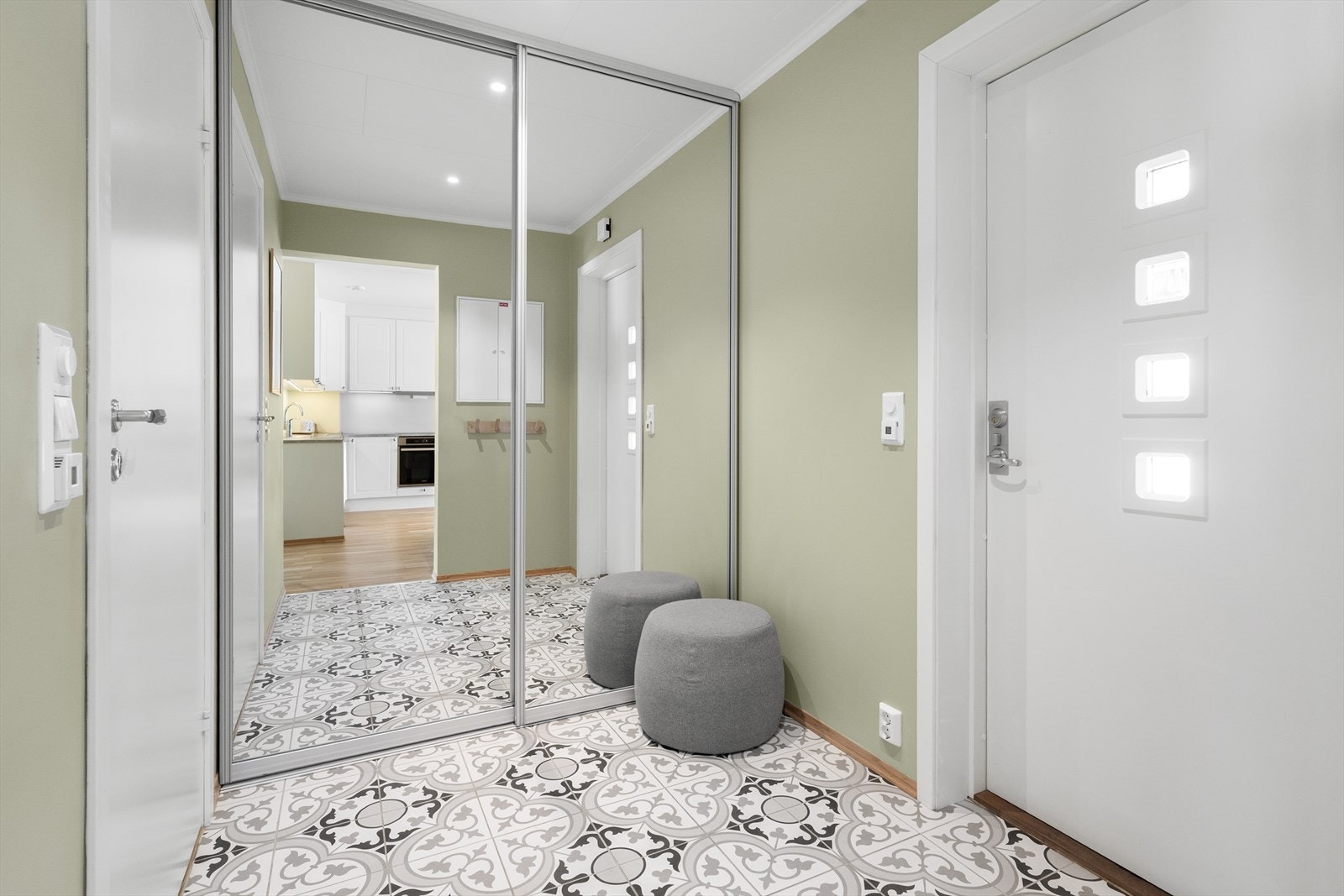 Lys og hyggelig entre som ønsker velkommen inn, hvor det er fliser på gulv med gulvvarme og ellers malte slette overflater. Stor, flott skyvedørsgarderobe som gir god plass til oppbevaring av klær og sko. Galleribilde