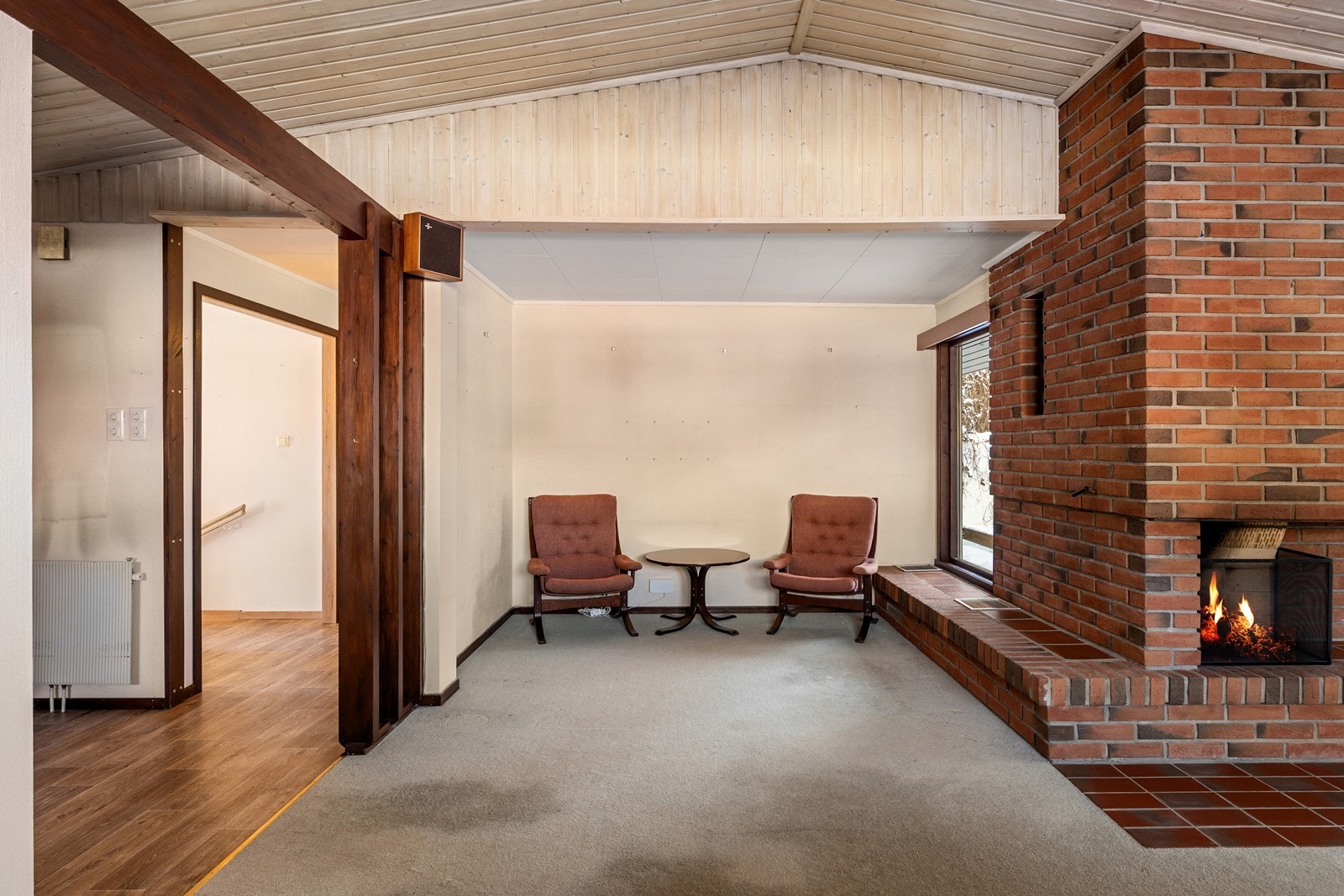 Videre har rommet plass til sofaseksjon, tv-møbel og spisegruppe. Det er montert en peis i rommet. Galleribilde