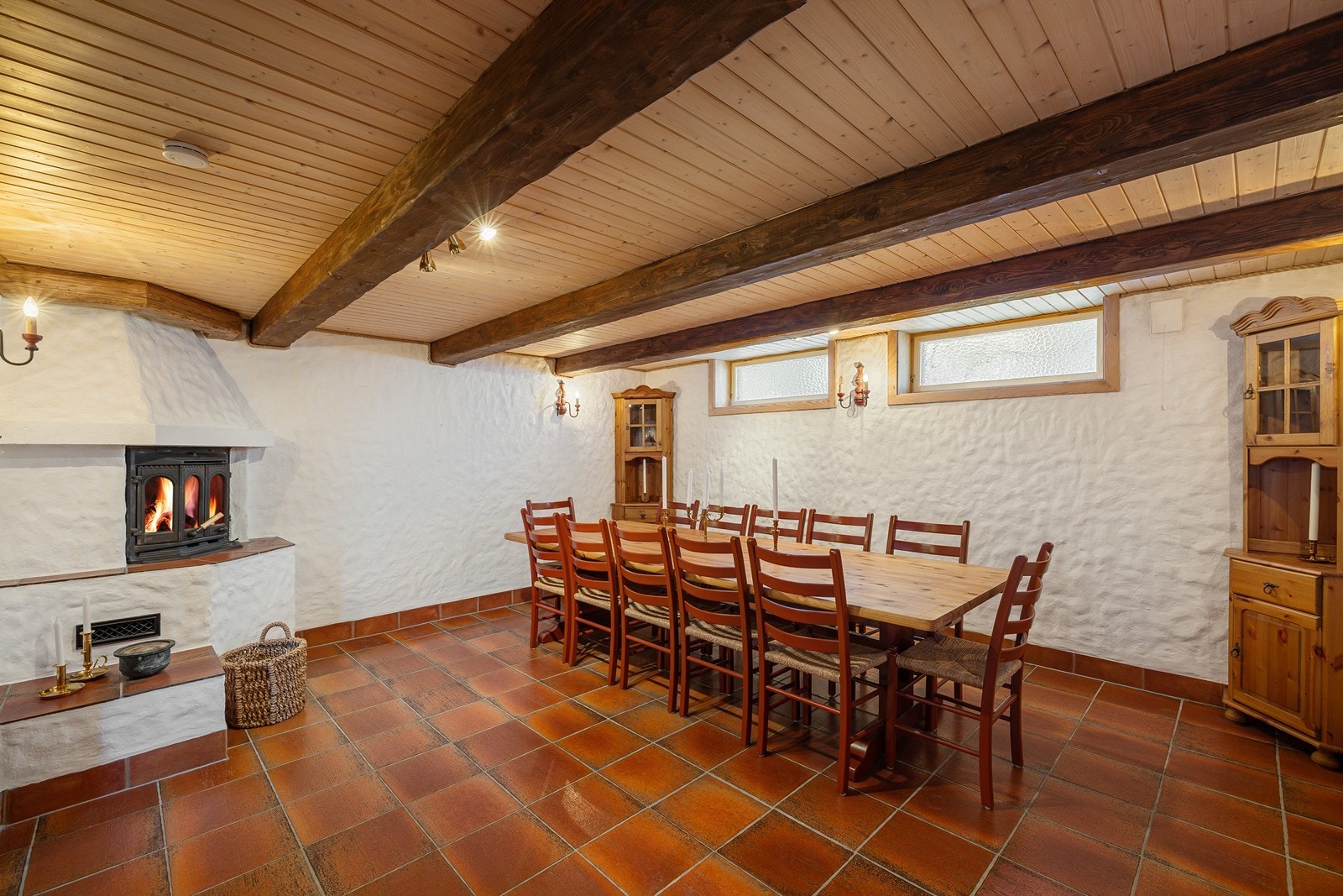 Innenfor vindfanget er det etablert en kjellerstue. Rommet har fliser på gulvet, samt synlige bjelker i taket. Galleribilde