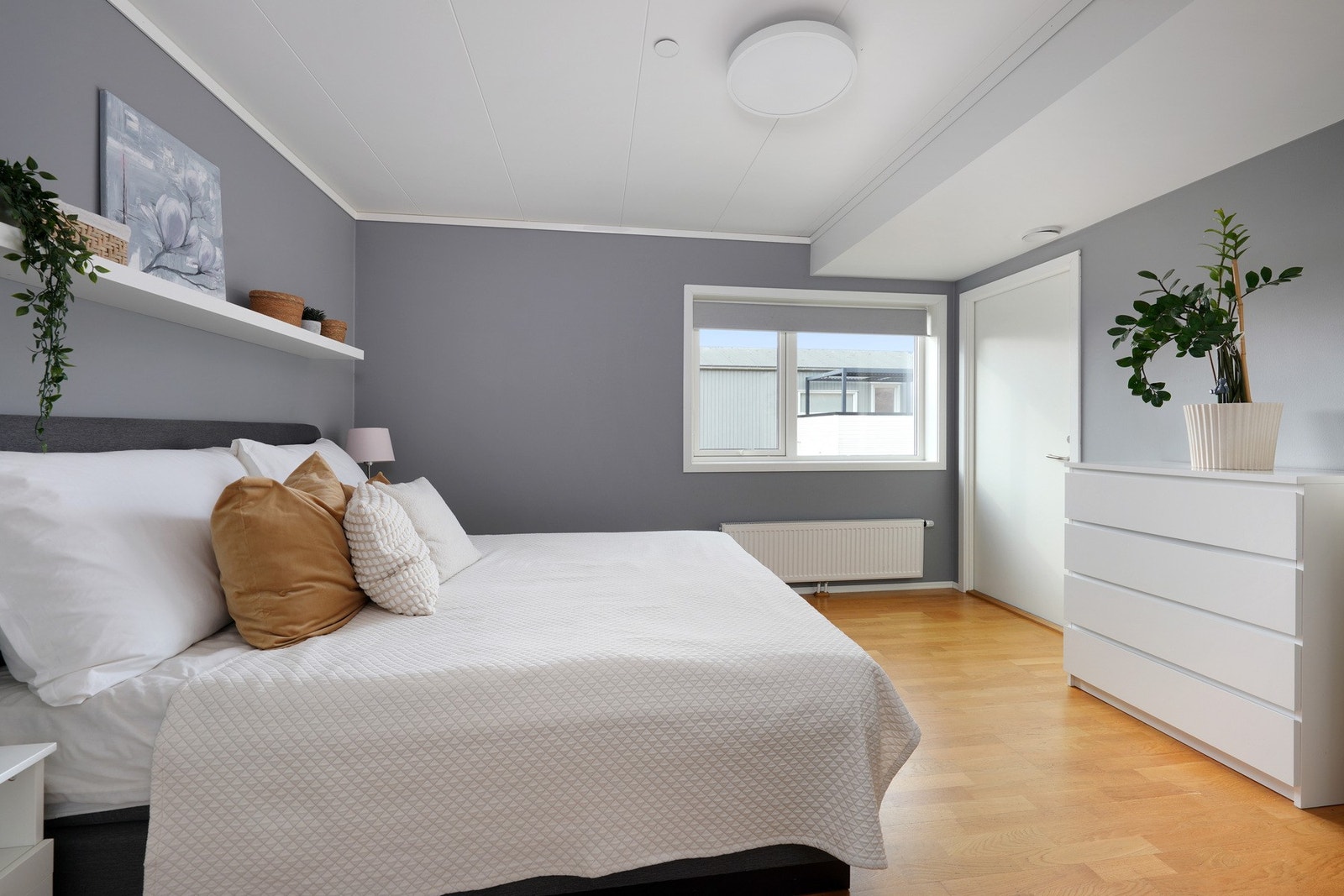 Stort romslig hovedsoverom med dirkte inngang til bod innredet som walk in-closet Galleribilde