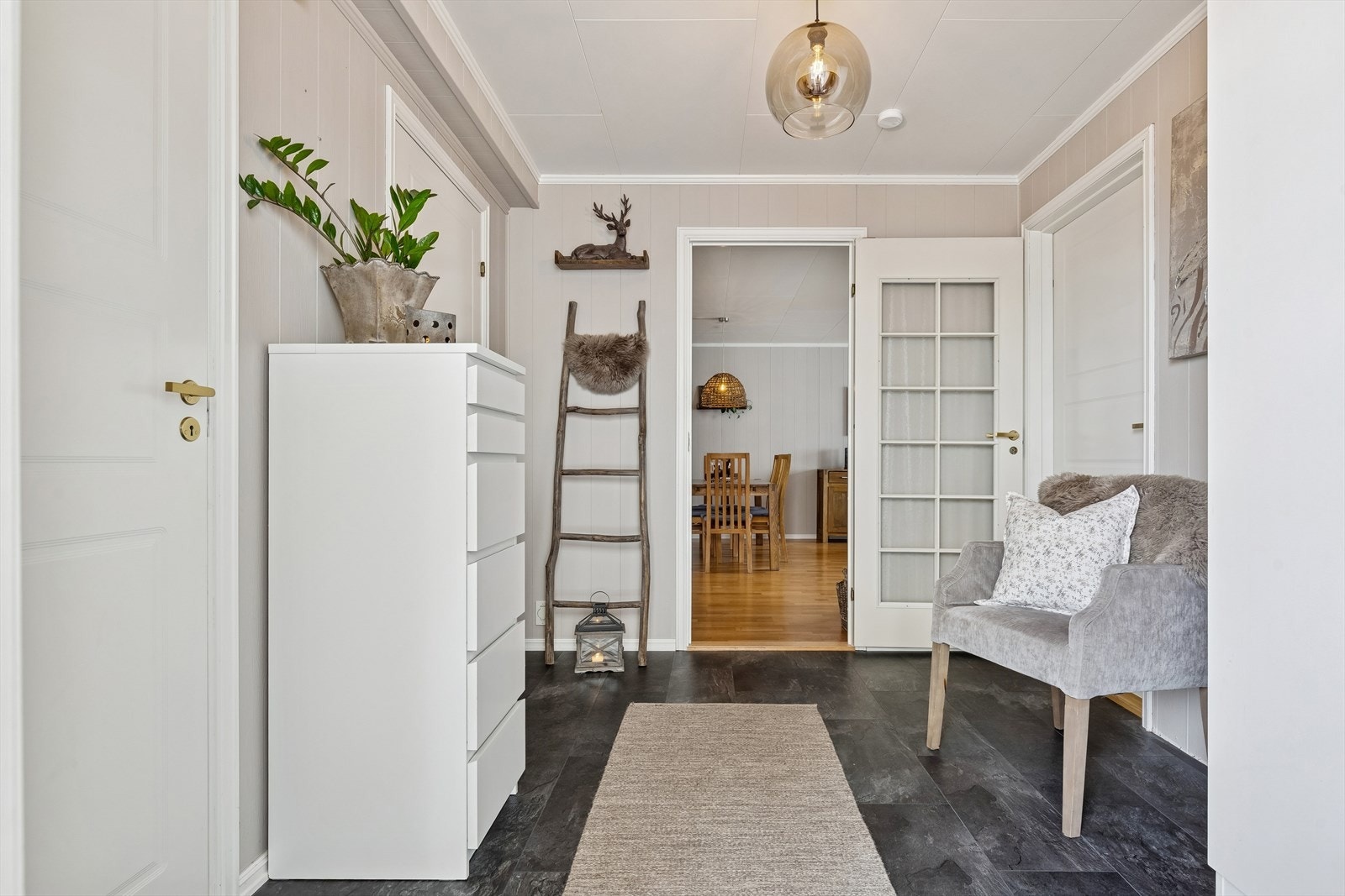 En romslig entré med vinylfliser på gulvet ønsker velkommen inn. Galleribilde