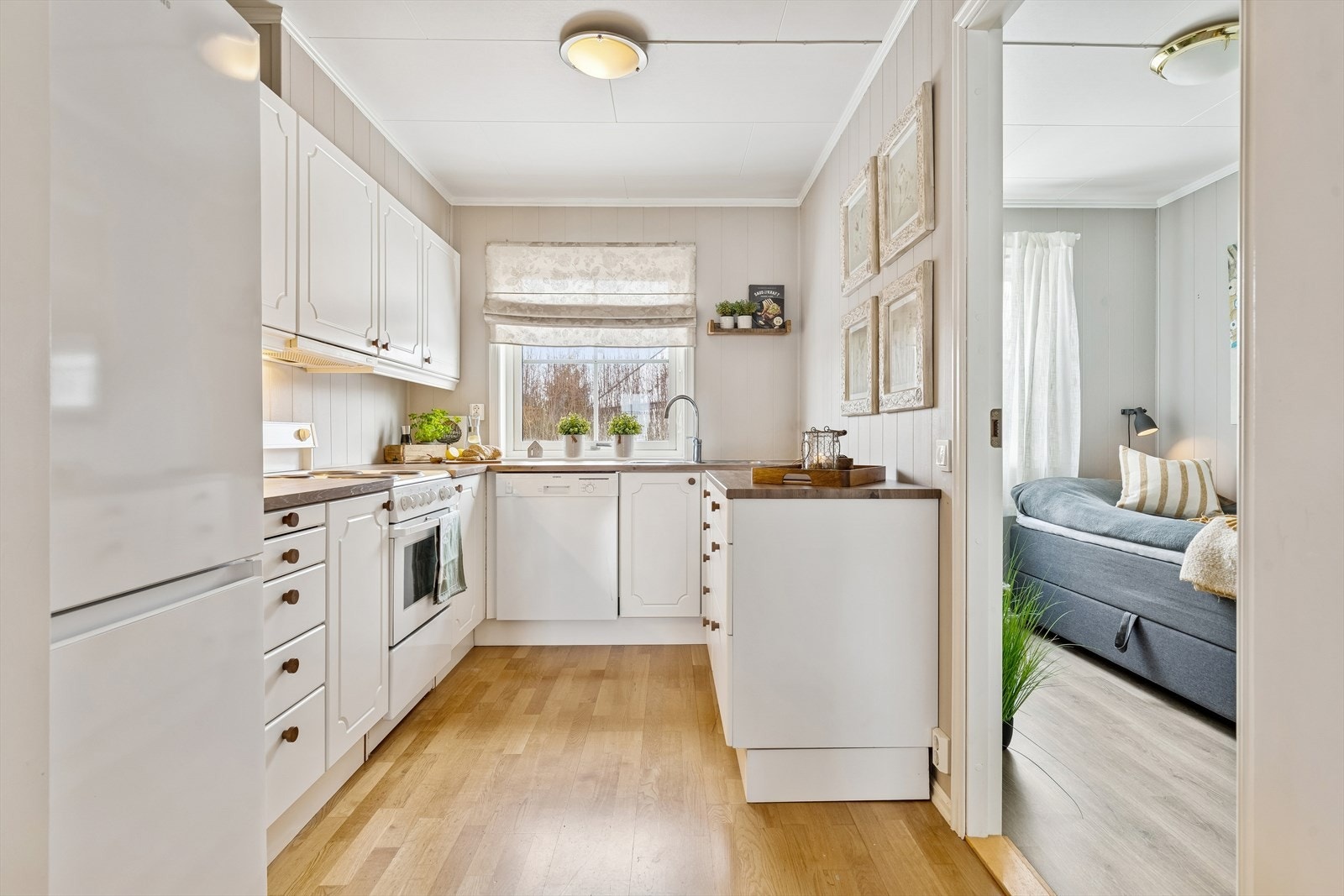 Kjøkkenet er utstyrt med komfyr, oppvaskmaskin og kjøleskap med fryserdel. Galleribilde